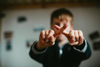 man in black and white jacket doing peace sign by Markus Spiske courtesy of Unsplash.